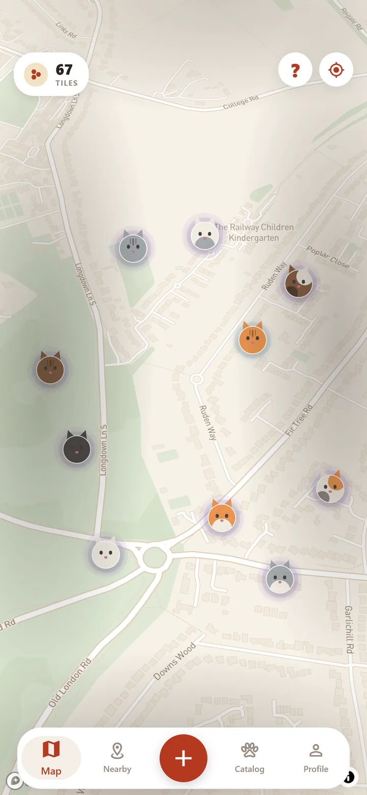 The map screen: cat pins scattered across a neighbourhood's streets, the rarer ones haloed in colour, with a counter showing 67 tiles uncovered.